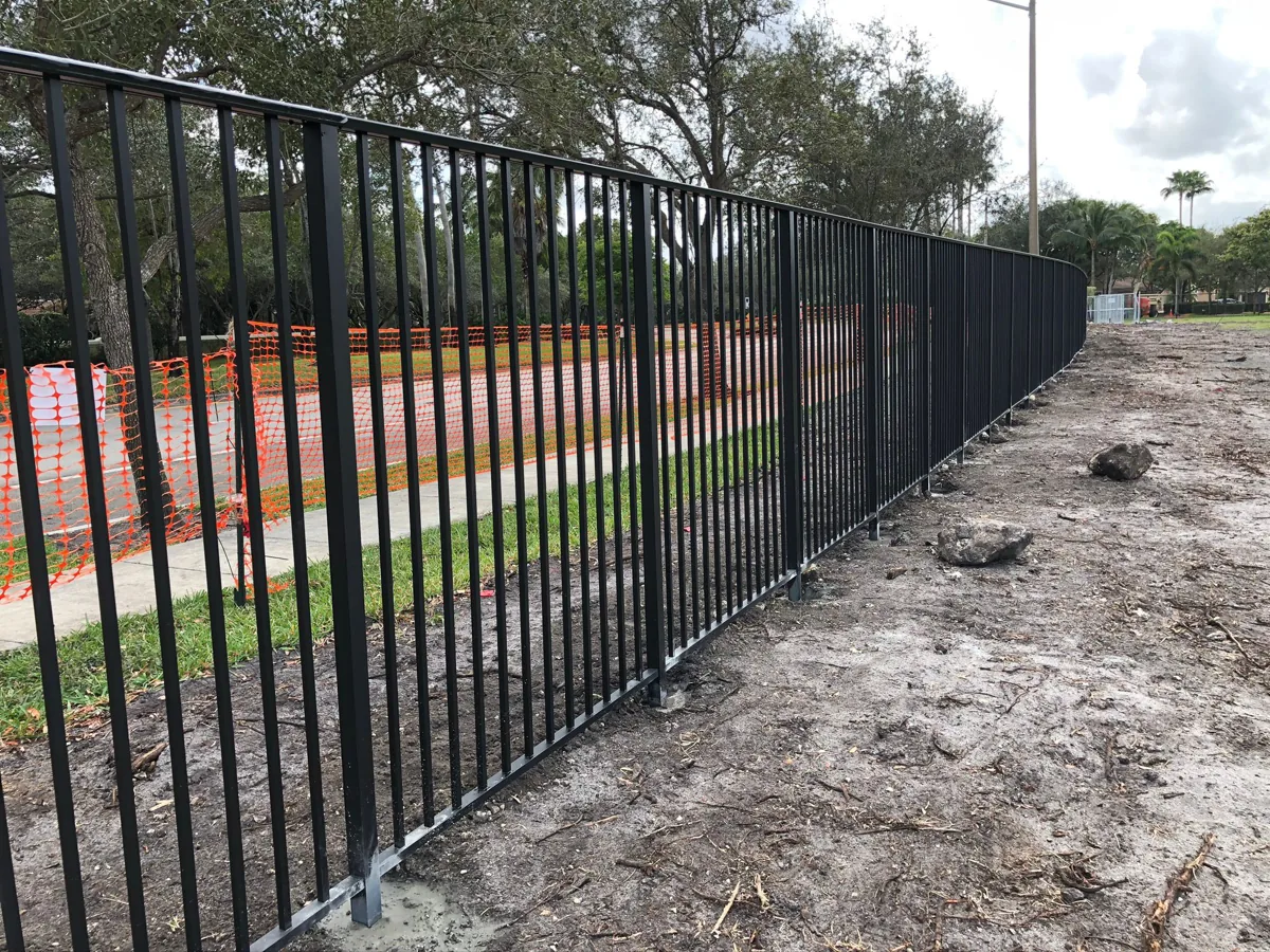 Black aluminum picket fence extending along a residential boundary
