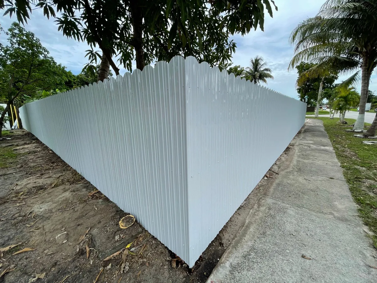 White vinyl privacy fence turning a corner beside a sidewalk