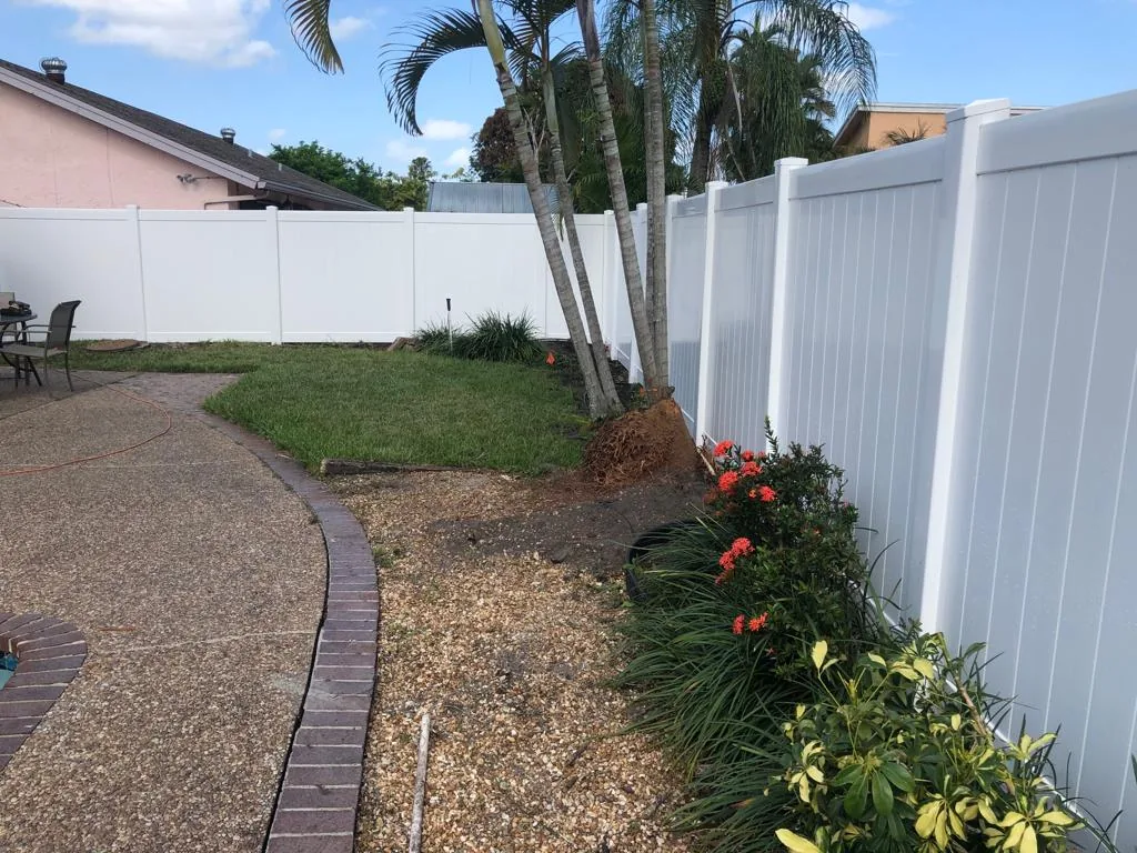 White vinyl privacy fence around a landscaped courtyard