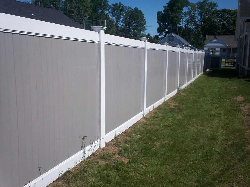 Long run of gray vinyl privacy fence with white posts