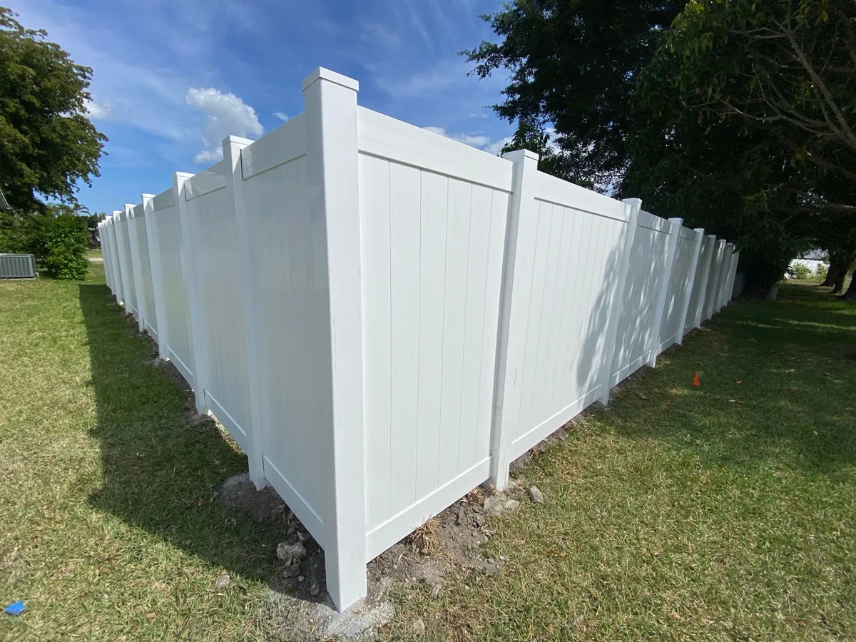 White vinyl privacy fence on a corner lot beside a lake