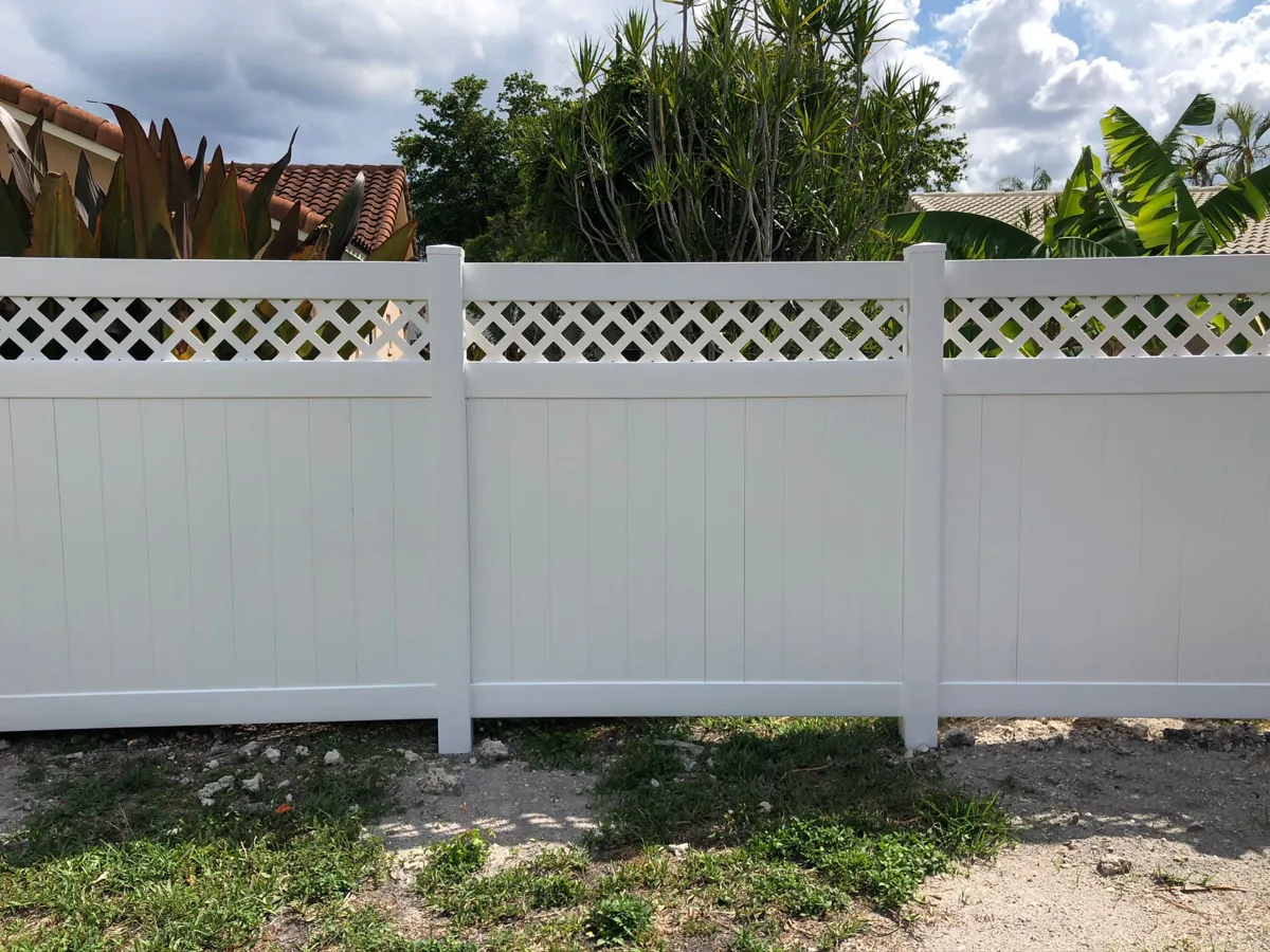 White vinyl privacy fence topped with an open lattice pattern