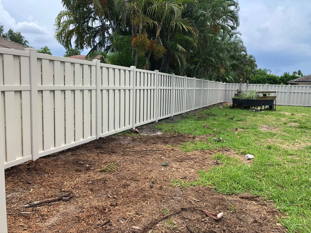 Cream shadowbox-style vinyl fence along a backyard