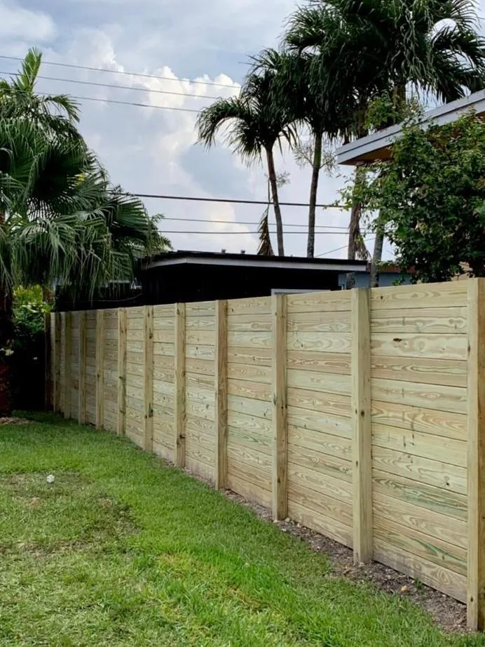 New horizontal wood board fence beside a lawn